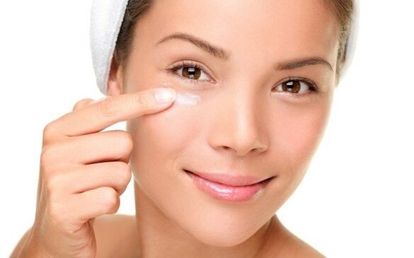 applying a cream to rejuvenate the skin around the eyes